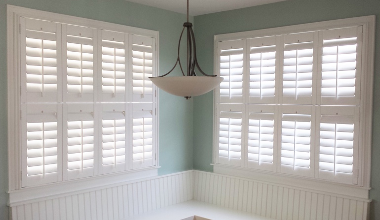 Pastel green wall in Austin kitchen with shutters.